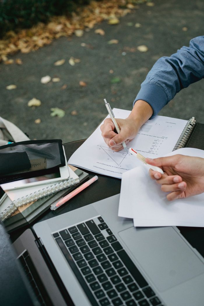 Crafting Captivating Headlines: Your awesome post title goes here From above crop faceless male students browsing laptop and taking notes in copybook while preparing for exam together in park